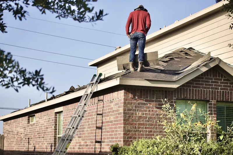 Professional roofer working on a residential roof in Warbasse